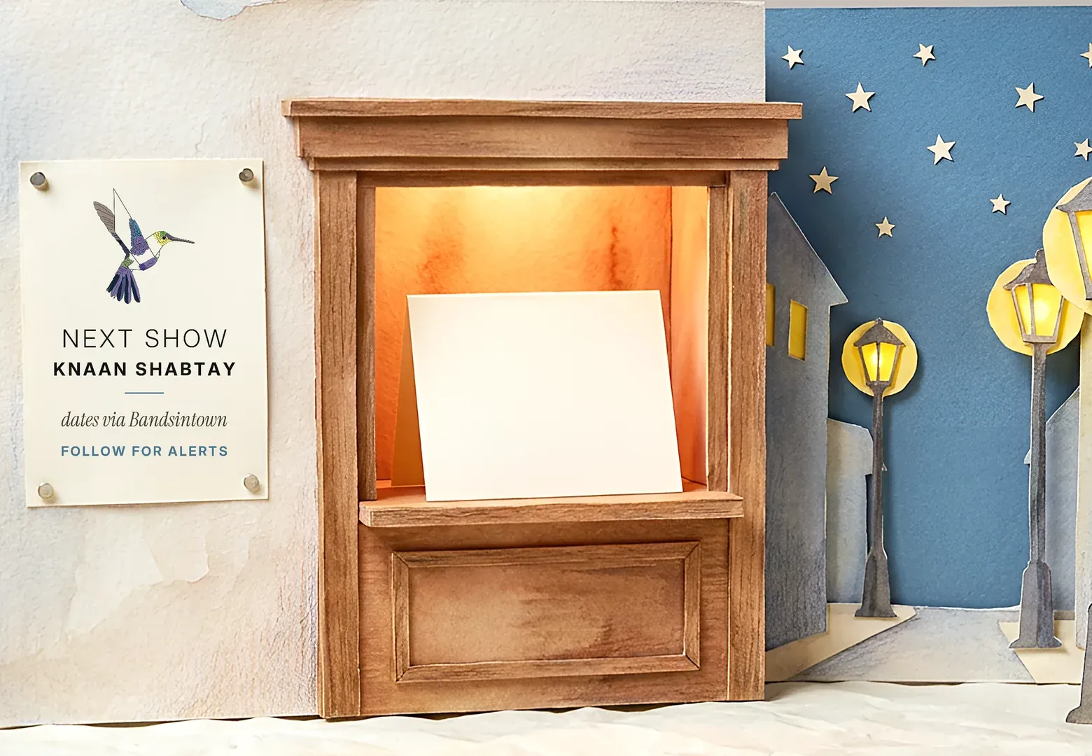 Paper box office with a lit window and a night street
