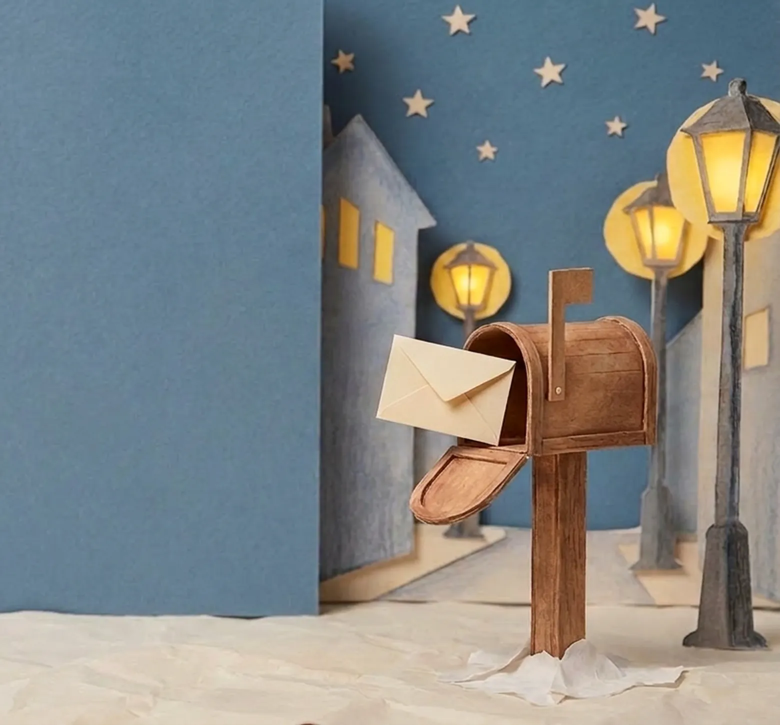 A paper mailbox with a letter on a snowy night street